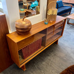 Load image into Gallery viewer, This 1960s Danish Mid Century Hutch exudes timeless elegance with its sleek design and functional features. It has three adjustable shelves, perfect for showcasing your most cherished items. The two sliding glass doors add a touch of sophistication while allowing easy access to your display pieces.
