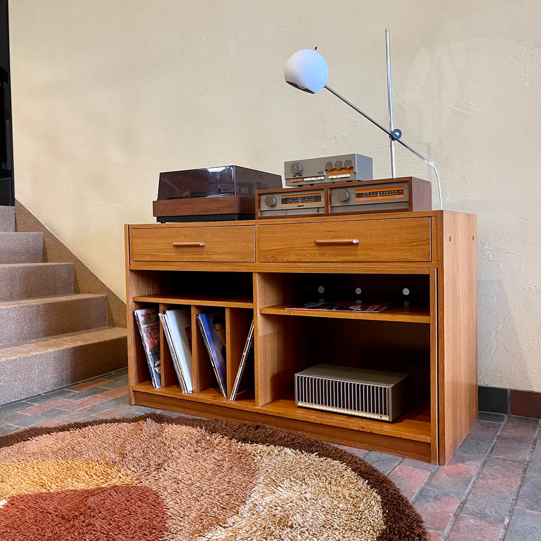 This versatile Adjustable Teak Entertainment Unit is an ideal fit for condo living. With ample storage including two drawers, it accommodates record collections and houses a stereo system
