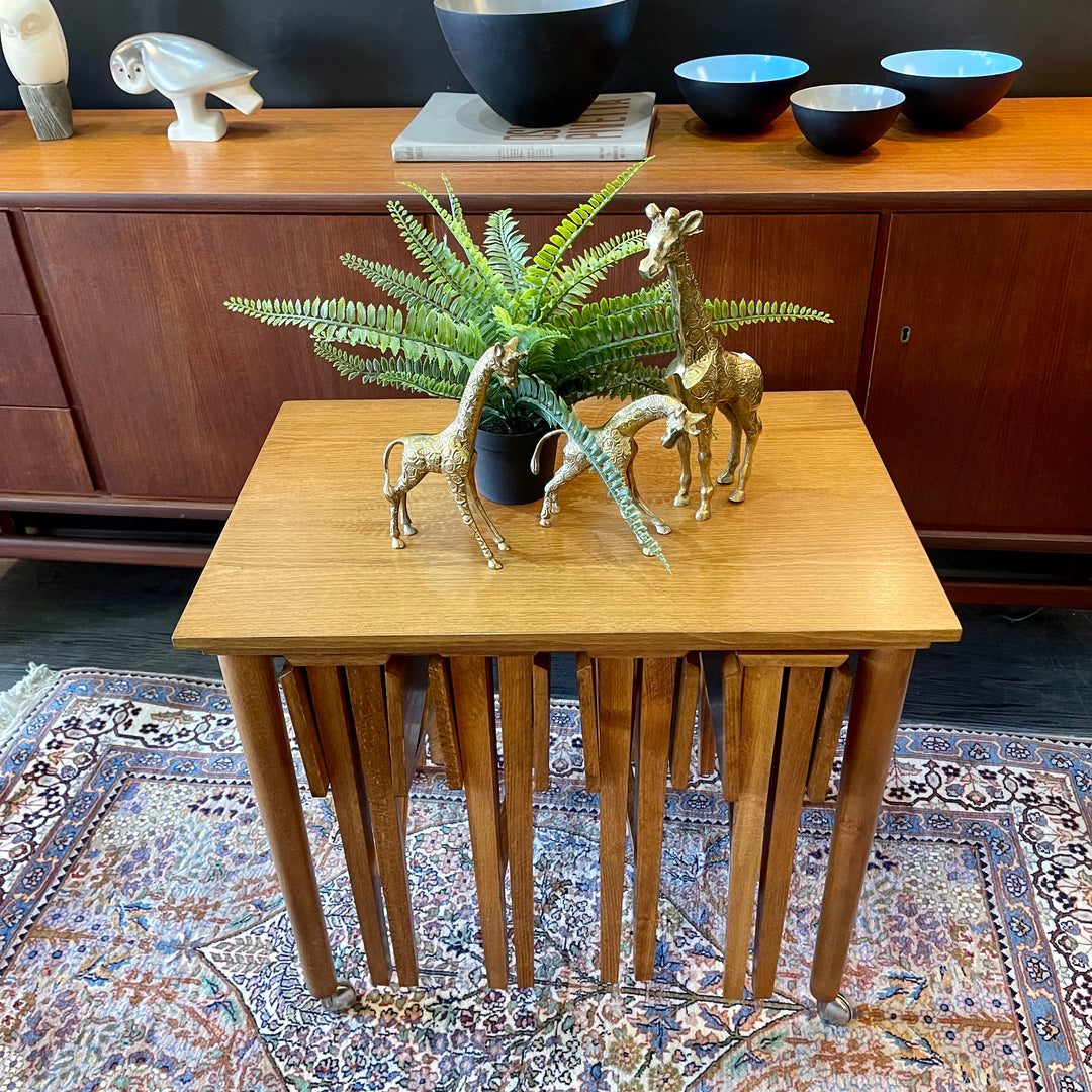 Mid Century Poul Hundevad Nesting Tables, a timeless and versatile addition to your living space. This exquisite set consists of five tables, with four of them ingeniously designed as drop-leaf tables that effortlessly slide beneath the main table, offering both functionality and aesthetic appeal.