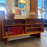 Load image into Gallery viewer, This 1960s Danish Mid Century Hutch exudes timeless elegance with its sleek design and functional features. It has three adjustable shelves, perfect for showcasing your most cherished items. The two sliding glass doors add a touch of sophistication while allowing easy access to your display pieces.
