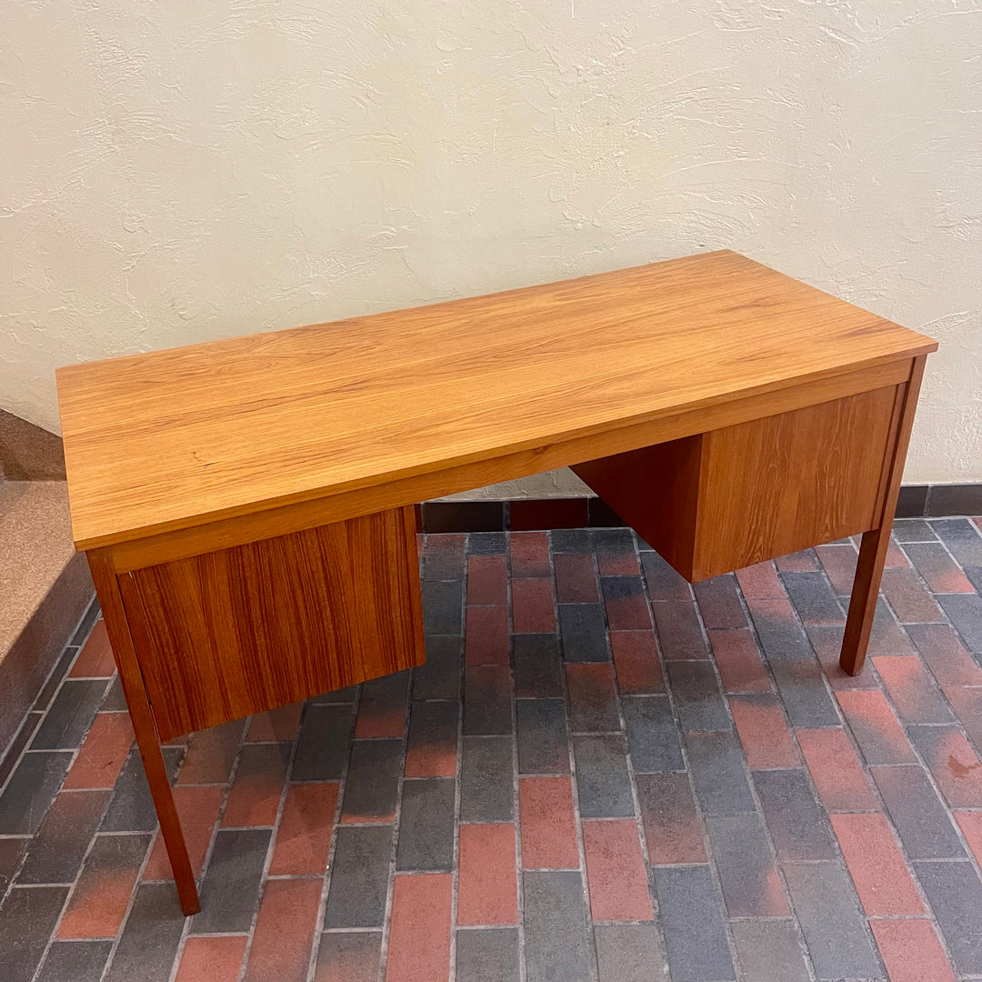 Mid Century Teak Finished Back Desk. This desk has a total of 6 dovetailed drawers, 3 on each side. The pulls are brass adding a classy touch. The two top drawers on either side have locks (missing the key)  The back of the desk is beautifully finished  with teak panels, perfect to place in the middle of the room. 