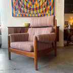Mid-century Danish teak lounge chair with a high back, padded armrests, deep seat, and striped blush pink and cream upholstery in Scandinavian modern style.
