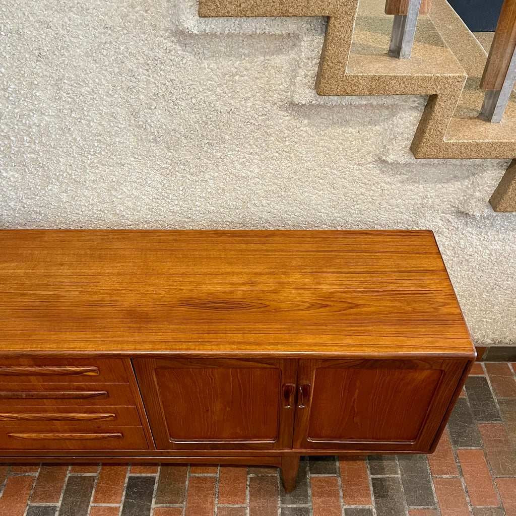 Crafted with attention to detail, this Mid Century Modern "Fresco" Teak Credenza by G Plan features four dovetail drawers for convenient storage, seamlessly integrated with additional storage on either side, offering even more organizational space.