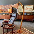 Mid-century arched wood floor lamp with pink shade, round base and sculptural curved frame