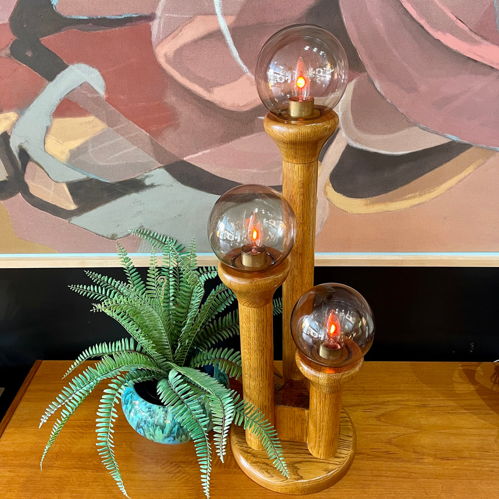 Close-up of smoky globe shade with bulbs lit on Space Age Modeline lamp