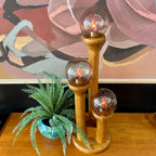 Close-up of smoky globe shade with bulbs lit on Space Age Modeline lamp