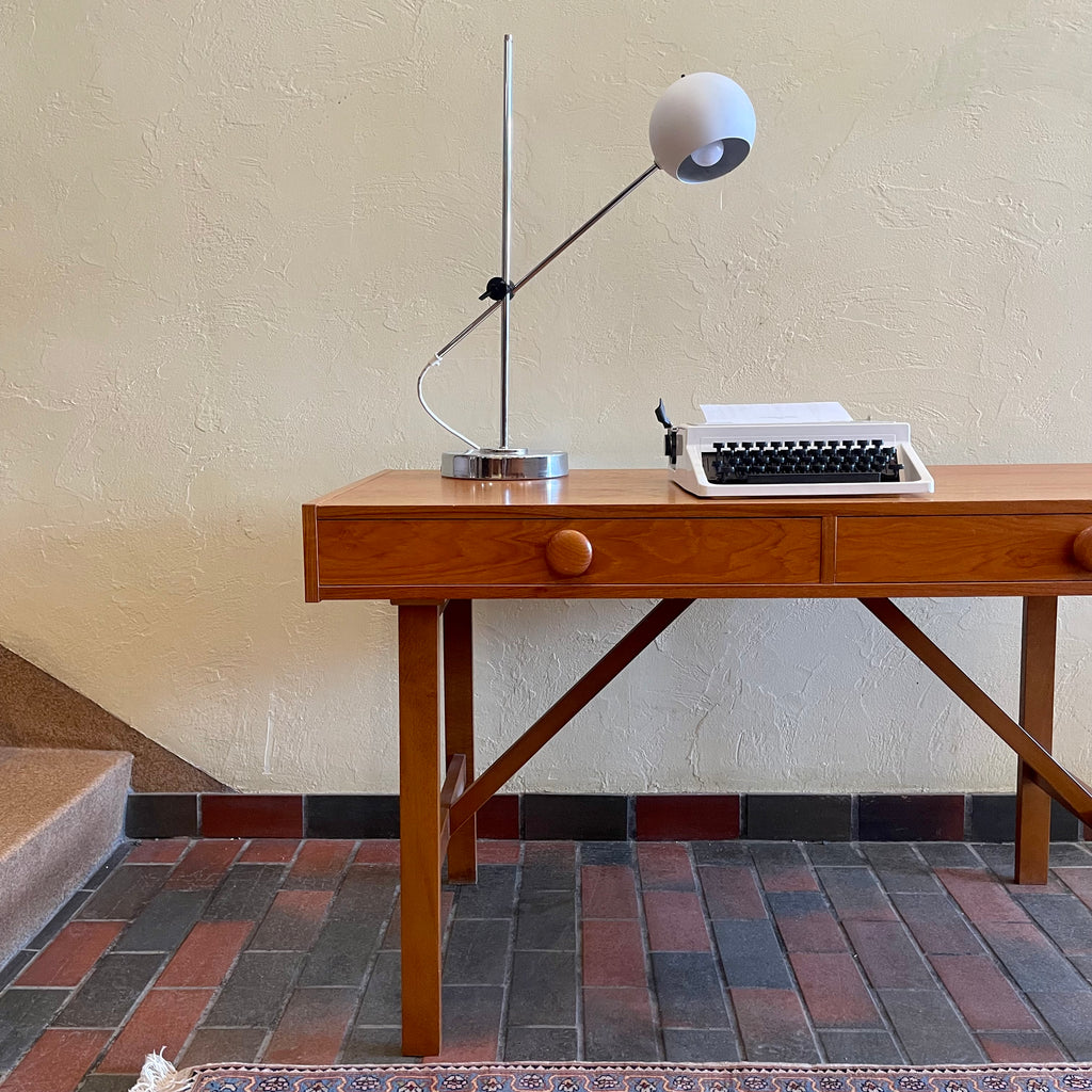  This Mid Century Danish Teak Desk epitomizes timeless design with its sleek lines and warm teak wood. Featuring two drawers, it offers practical storage while maintaining a minimalist aesthetic.