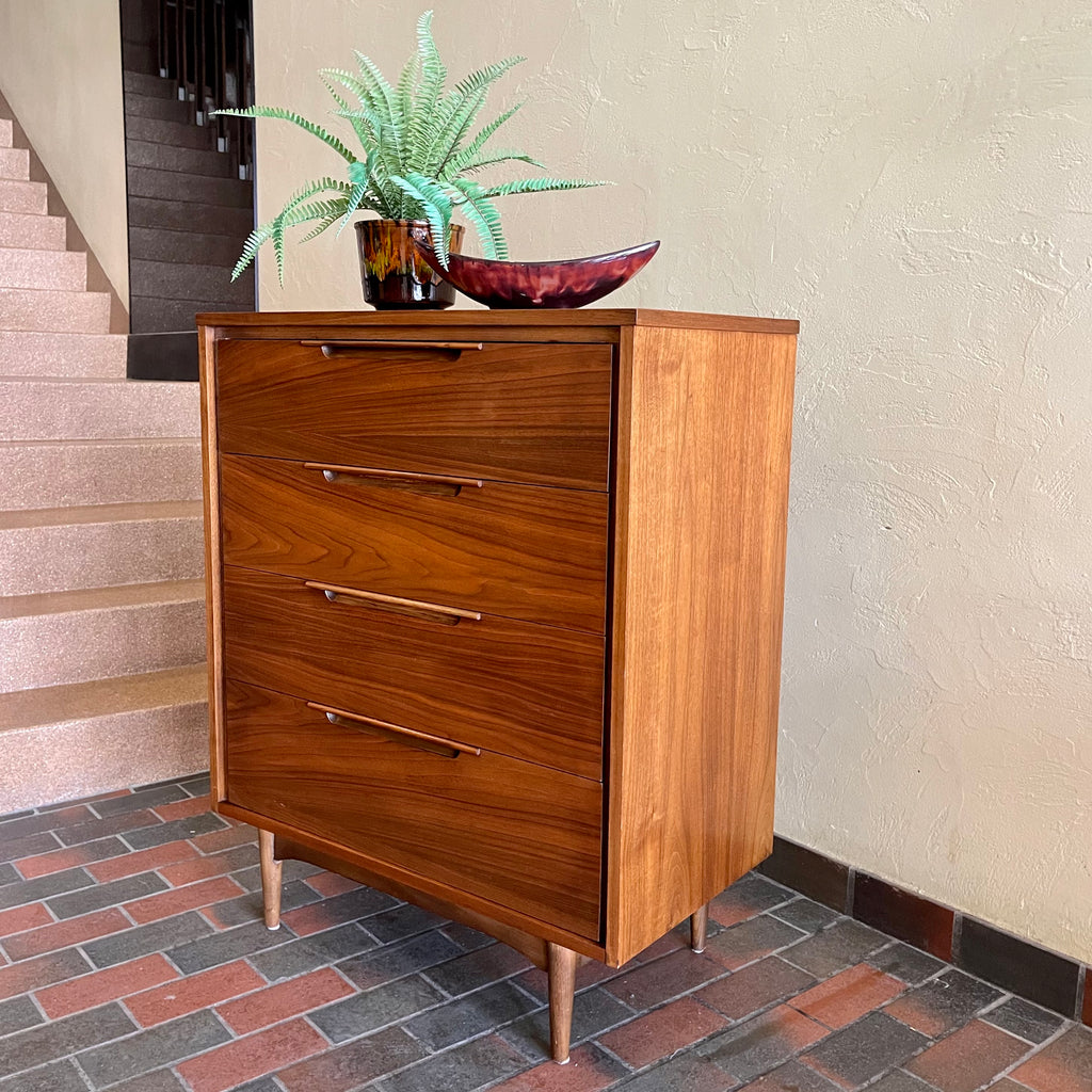 This Vintage KRUG Walnut Tallboy Dresser features four drawers and is made of rich dark walnut wood. Its classic design and high-quality construction make it a timeless addition to any bedroom. 