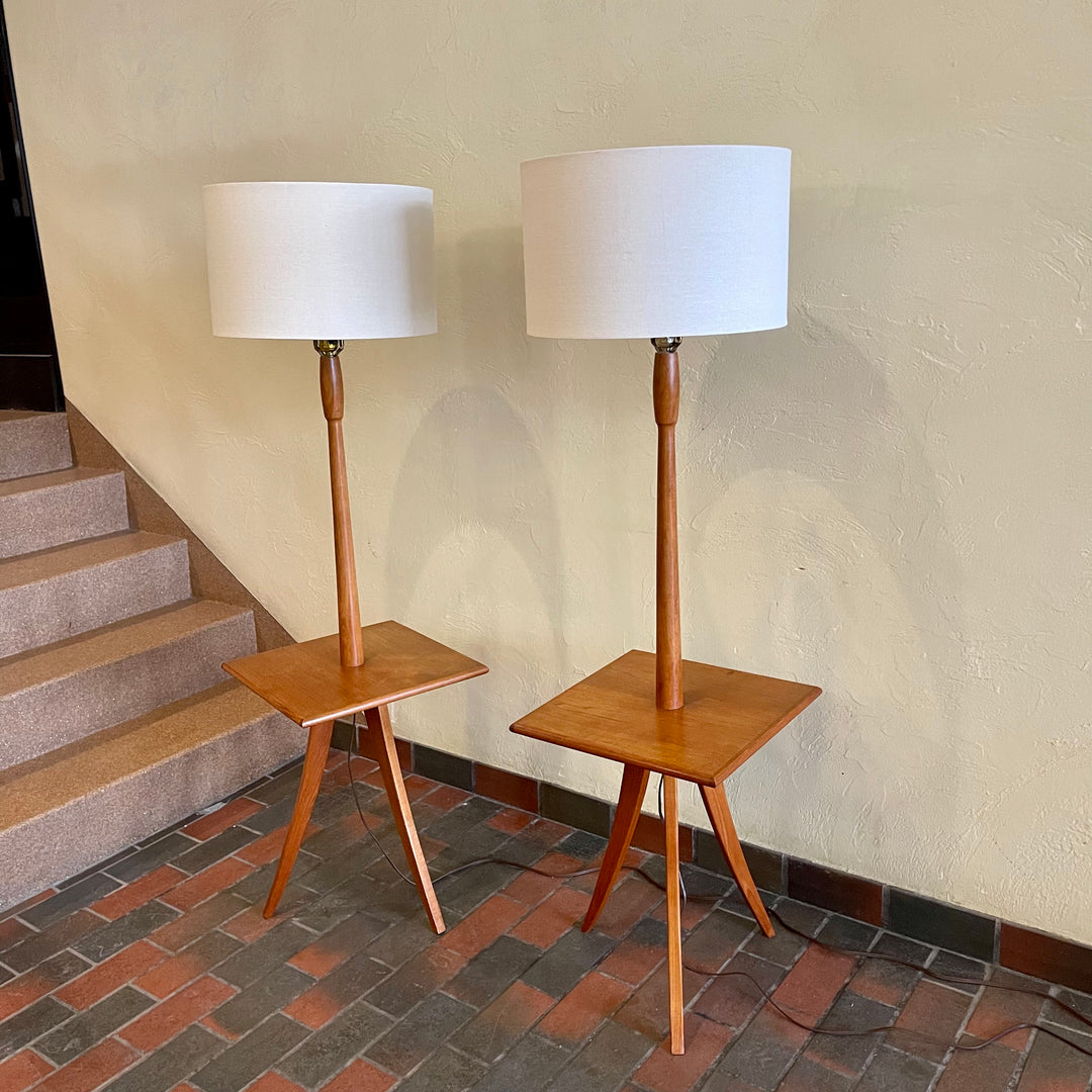  Mid Century Teak Tri-pod Side Table Lamps,are crafted with the sophistication of mid-century design, these lamps boast a rich teak finish that exudes warmth and refinement. The slender tripod base gracefully elevates the table and the lamps, creating a harmonious balance between simplicity and style.