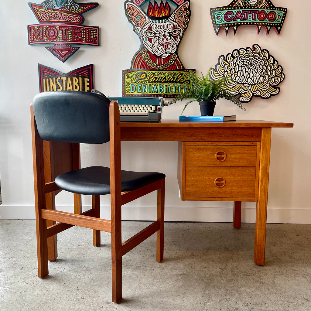 Mid-century teak desk with round drawer pulls, tapered legs and matching black upholstered chair