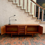 Crafted with attention to detail, this Mid Century Modern "Fresco" Teak Credenza by G Plan features four dovetail drawers for convenient storage, seamlessly integrated with additional storage on either side, offering even more organizational space.
