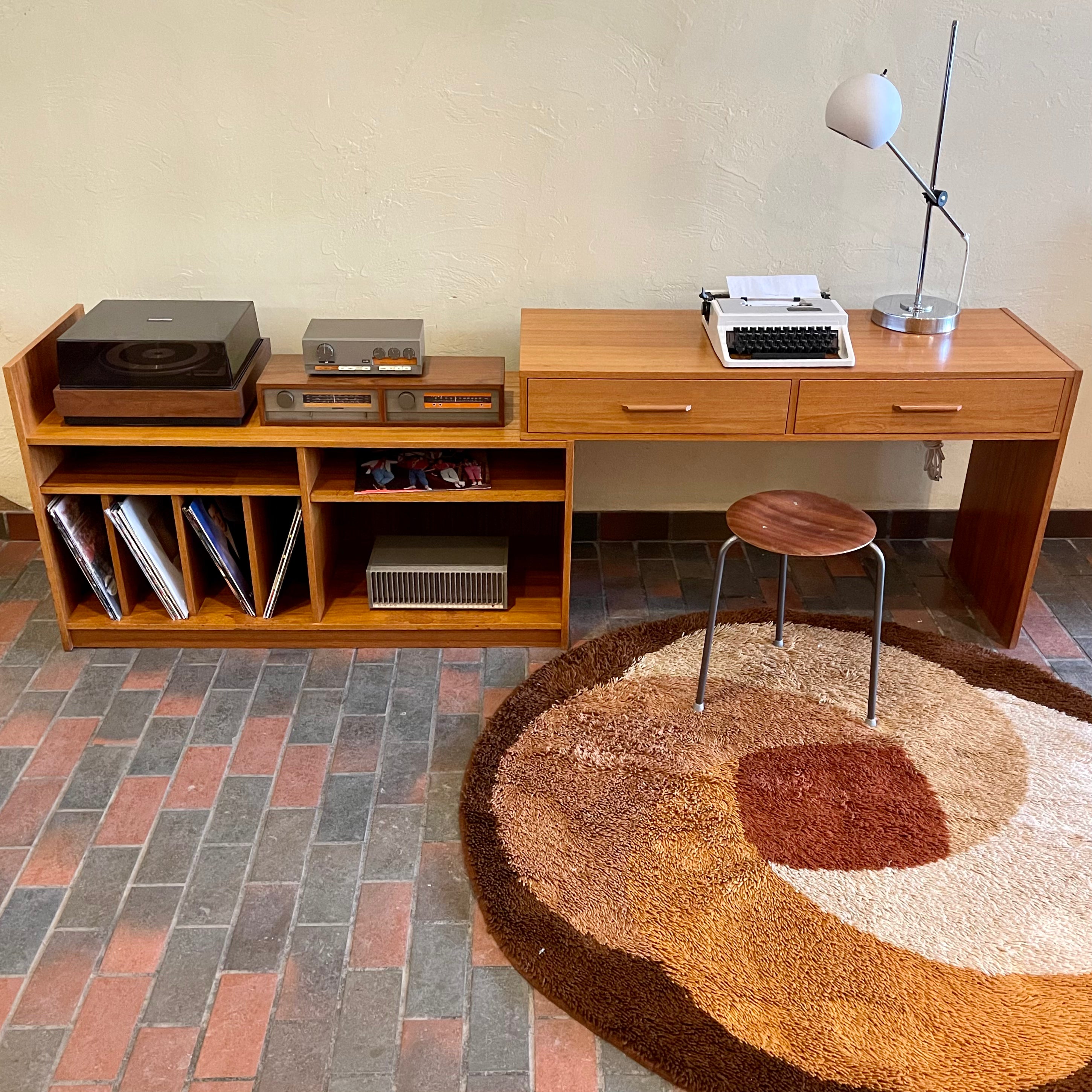 This versatile Adjustable Teak Entertainment Unit is an ideal fit for condo living. With ample storage including two drawers, it accommodates record collections and houses a stereo system