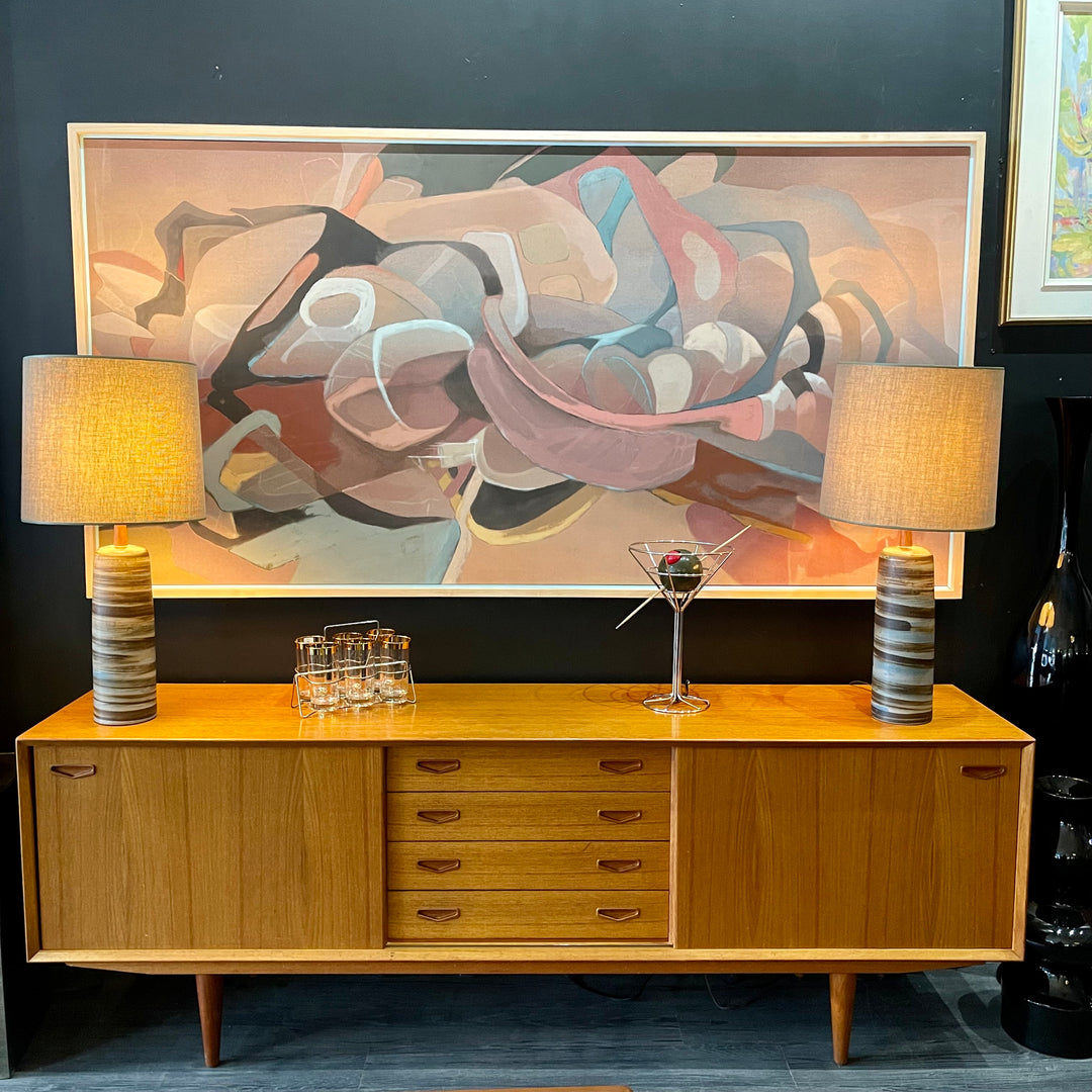 1960s Danish Teak Credenza is a beautiful blend of mid-century design and functionality. Crafted from teak, it features two sliding doors on either side that open to reveal ample storage space with adjustable shelving