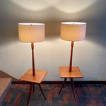 Load image into Gallery viewer,  Mid Century Teak Tri-pod Side Table Lamps,are crafted with the sophistication of mid-century design, these lamps boast a rich teak finish that exudes warmth and refinement. The slender tripod base gracefully elevates the table and the lamps, creating a harmonious balance between simplicity and style.
