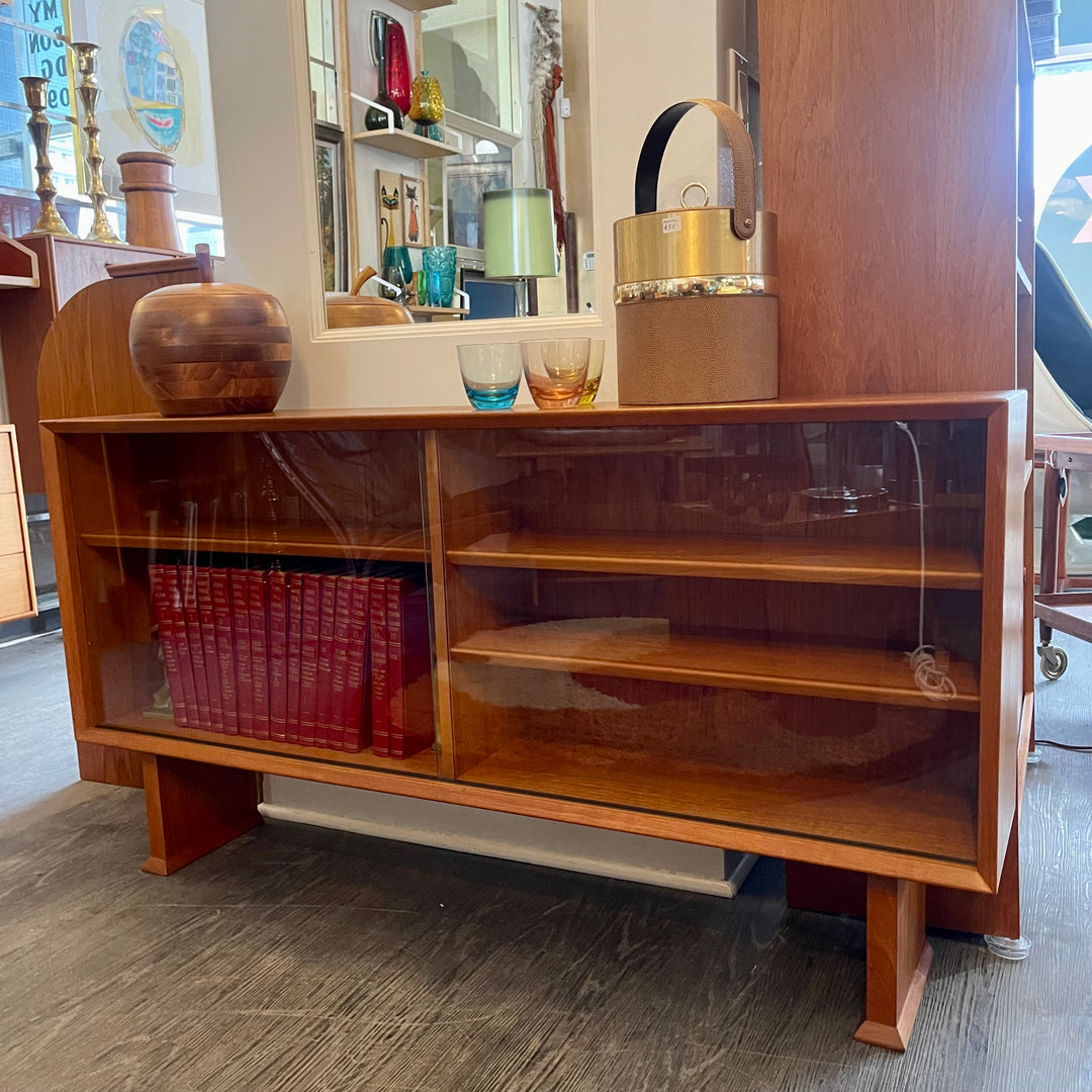 This 1960s Danish Mid Century Hutch exudes timeless elegance with its sleek design and functional features. It has three adjustable shelves, perfect for showcasing your most cherished items. The two sliding glass doors add a touch of sophistication while allowing easy access to your display pieces.