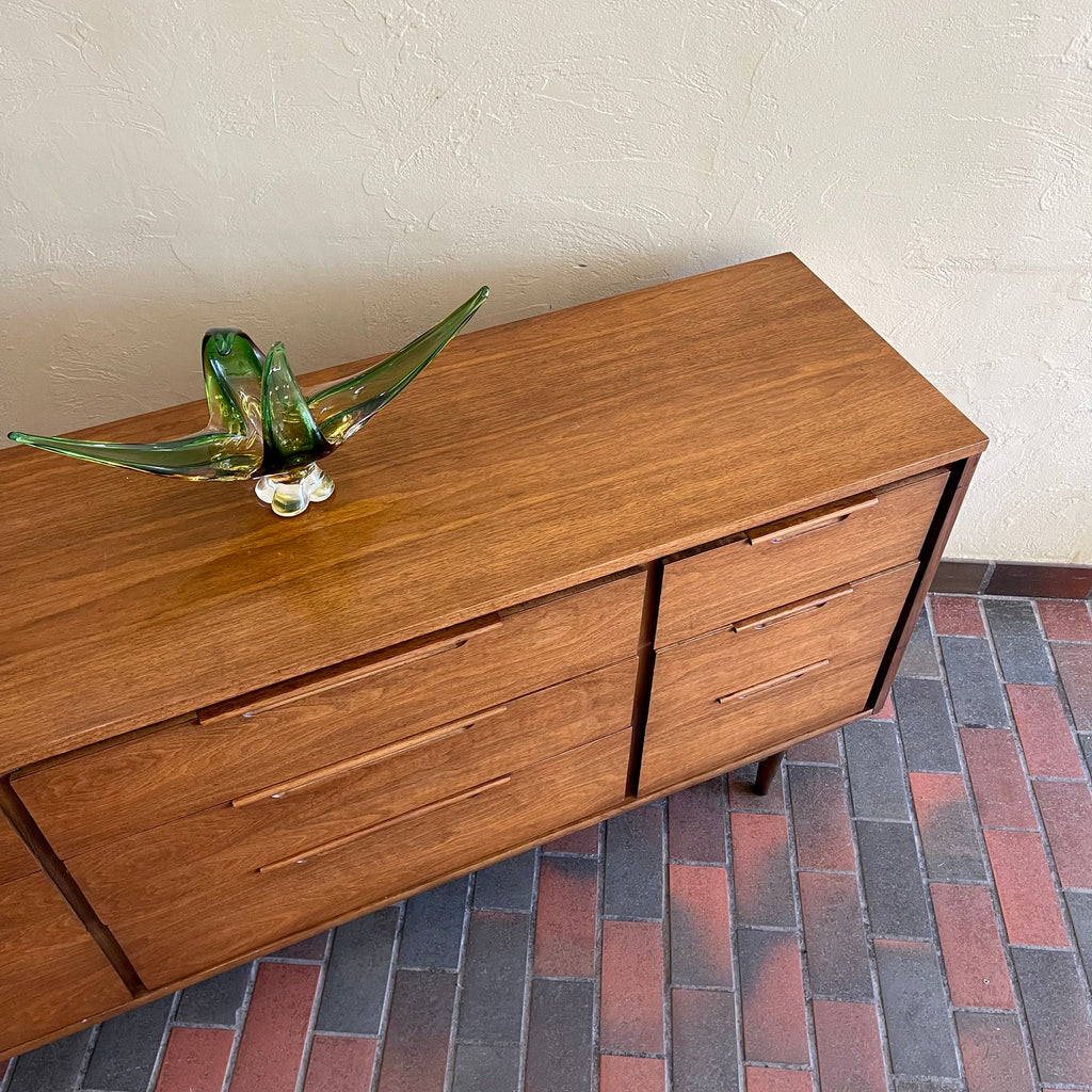 Enhance your bedroom with this Vintage KRUG Walnut 9 Drawer Dresser. The warm, rich color of the walnut complements any decor. Its sleek handle pulls add a touch of elegance to the design. With 9 spacious drawers, this dresser provides ample storage. 