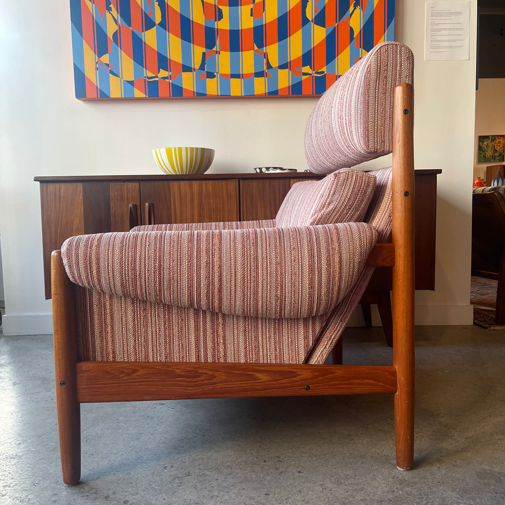 Side view of Danish teak lounge chair with high back and padded armrests