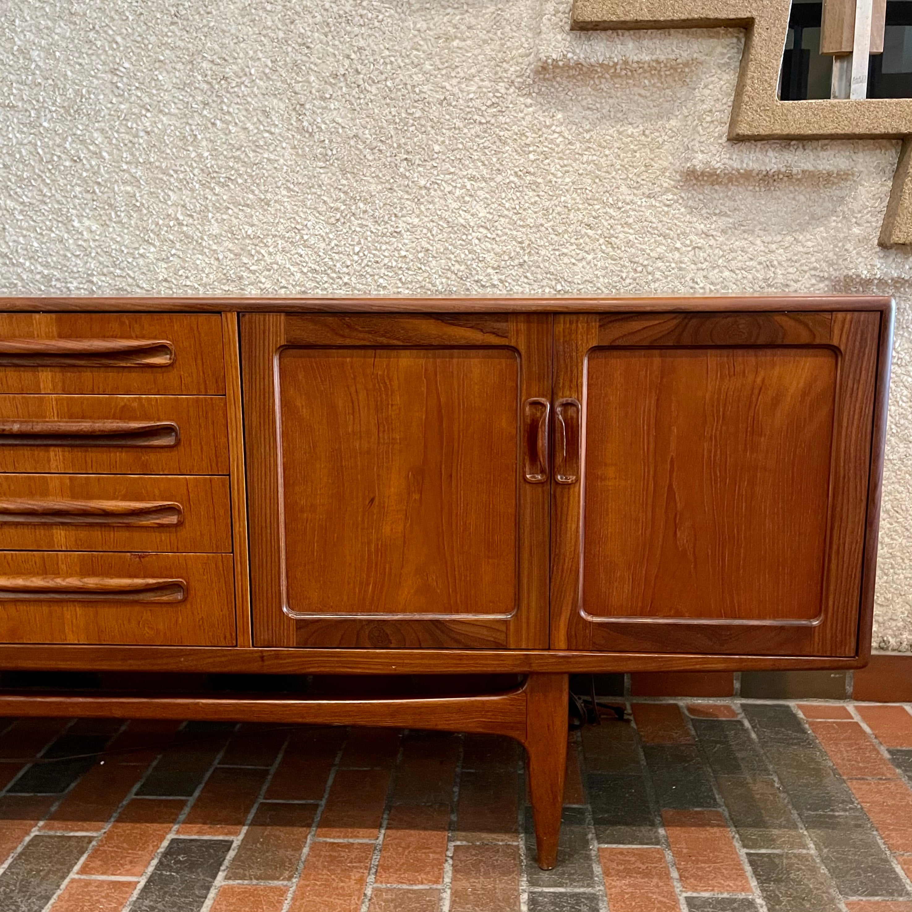 Crafted with attention to detail, this Mid Century Modern "Fresco" Teak Credenza by G Plan features four dovetail drawers for convenient storage, seamlessly integrated with additional storage on either side, offering even more organizational space.