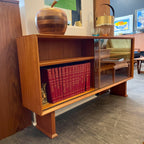 This 1960s Danish Mid Century Hutch exudes timeless elegance with its sleek design and functional features. It has three adjustable shelves, perfect for showcasing your most cherished items. The two sliding glass doors add a touch of sophistication while allowing easy access to your display pieces.
