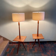  Mid Century Teak Tri-pod Side Table Lamps,are crafted with the sophistication of mid-century design, these lamps boast a rich teak finish that exudes warmth and refinement. The slender tripod base gracefully elevates the table and the lamps, creating a harmonious balance between simplicity and style.
