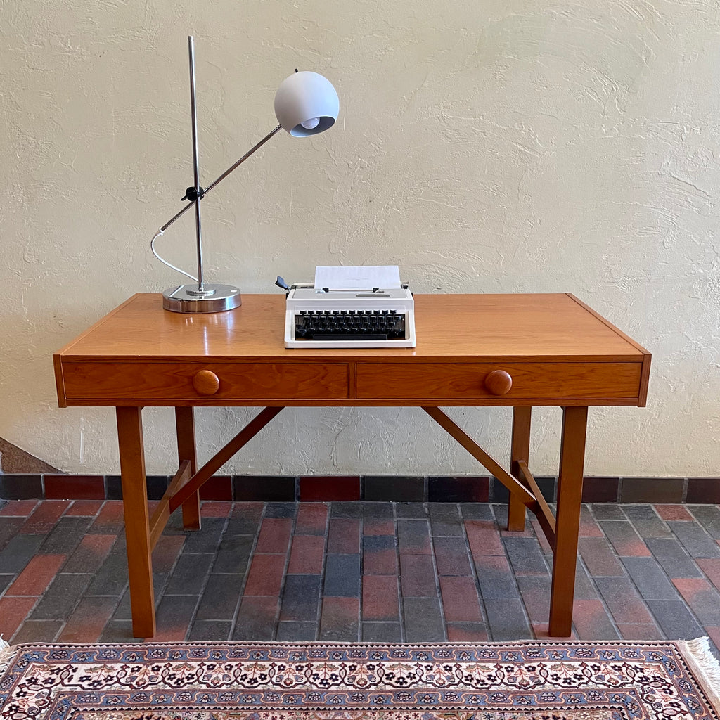 This Mid Century Danish Teak Desk epitomizes timeless design with its sleek lines and warm teak wood. Featuring two drawers, it offers practical storage while maintaining a minimalist aesthetic.