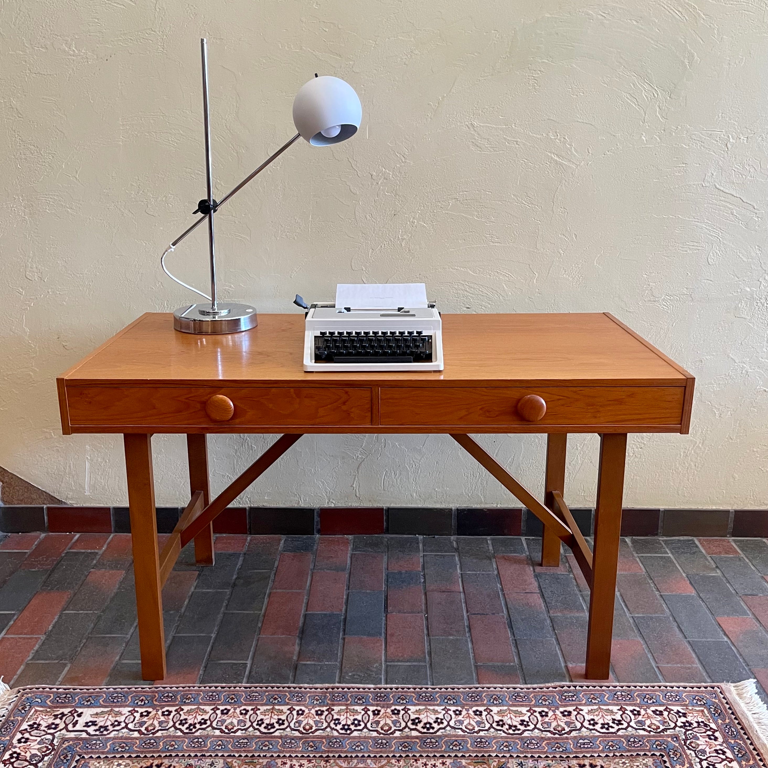  This Mid Century Danish Teak Desk epitomizes timeless design with its sleek lines and warm teak wood. Featuring two drawers, it offers practical storage while maintaining a minimalist aesthetic.
