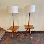 Load image into Gallery viewer,  Mid Century Teak Tri-pod Side Table Lamps,are crafted with the sophistication of mid-century design, these lamps boast a rich teak finish that exudes warmth and refinement. The slender tripod base gracefully elevates the table and the lamps, creating a harmonious balance between simplicity and style.

