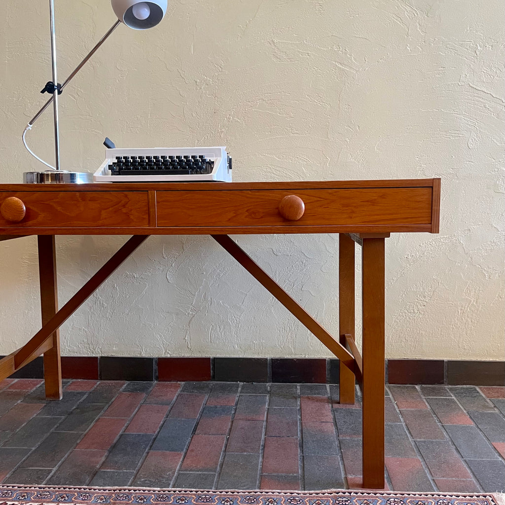  This Mid Century Danish Teak Desk epitomizes timeless design with its sleek lines and warm teak wood. Featuring two drawers, it offers practical storage while maintaining a minimalist aesthetic.