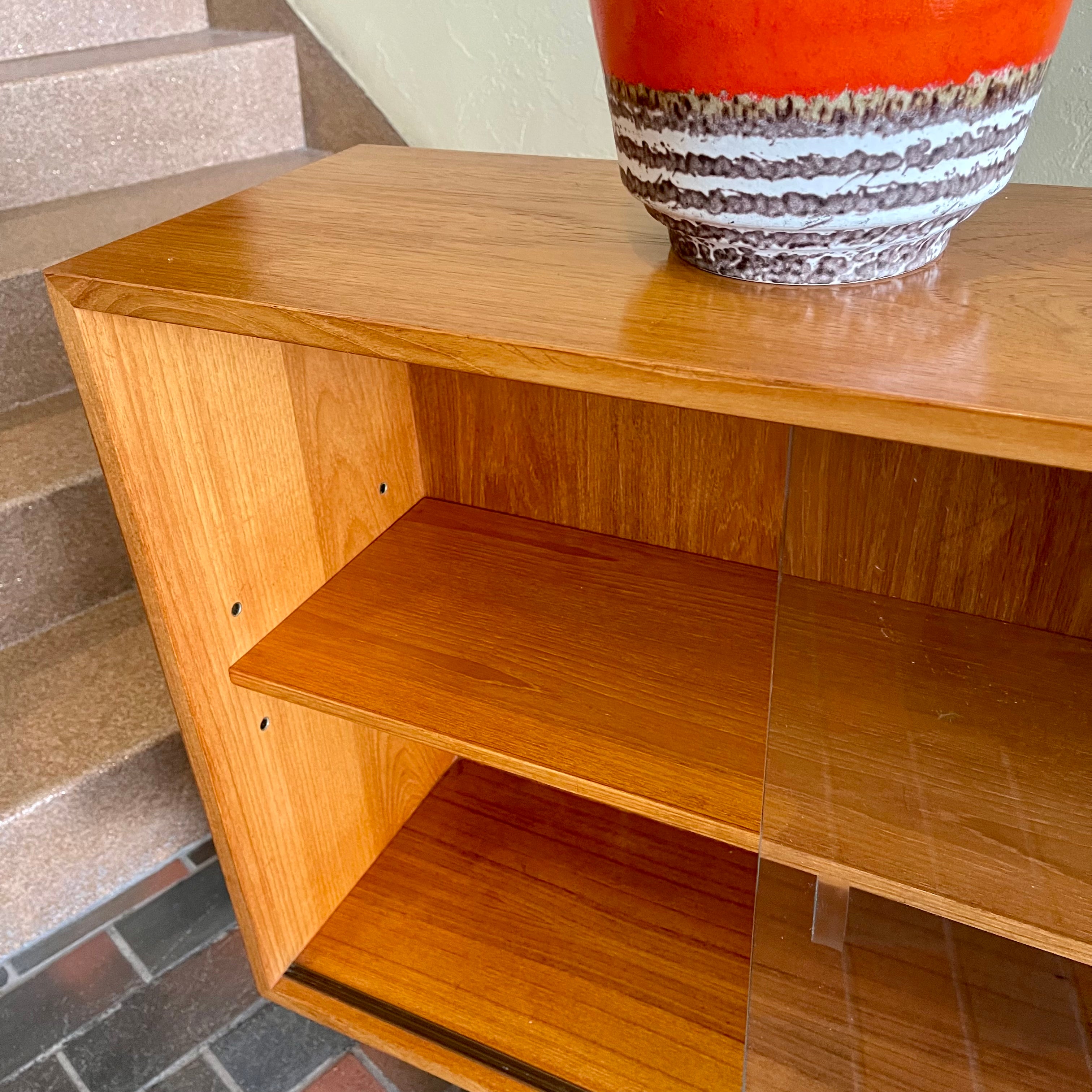  Mid-century Teak Credenza | Hutch with Adjustable Shelving. This mid-century teak credenza | hutch is perfect for storing and displaying your items. Featuring two adjustable shelves, you can customize the configuration to suit your unique home. The timeless design is ideal for both office and home environments.