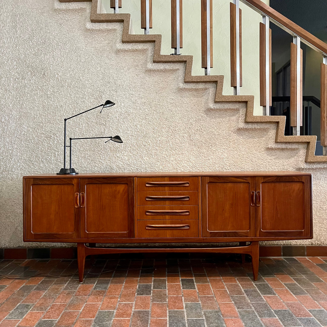 Crafted with attention to detail, this Mid Century Modern "Fresco" Teak Credenza by G Plan features four dovetail drawers for convenient storage, seamlessly integrated with additional storage on either side, offering even more organizational space.