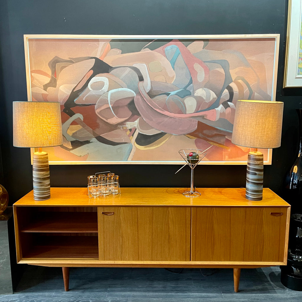 1960s Danish Teak Credenza is a beautiful blend of mid-century design and functionality. Crafted from teak, it features two sliding doors on either side that open to reveal ample storage space with adjustable shelving