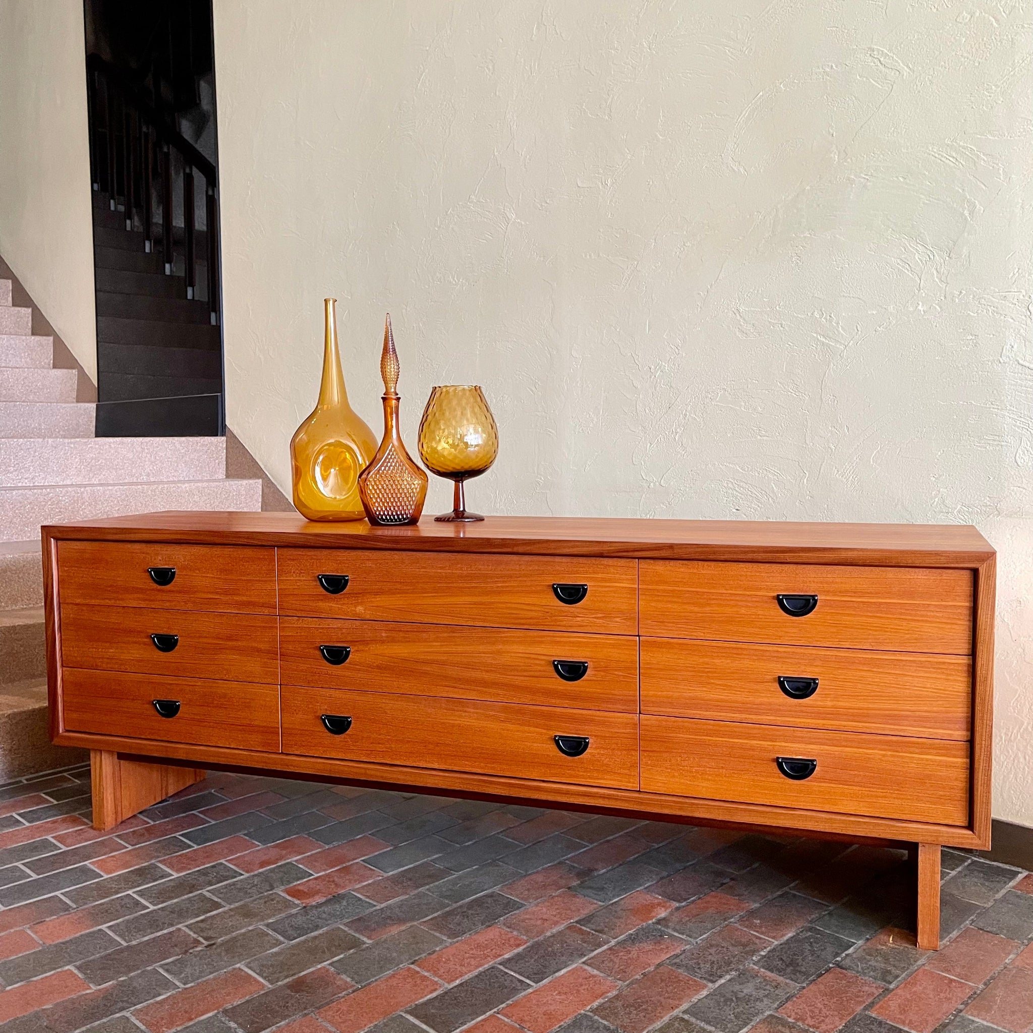 Mid-century R.S. Associates teak dresser with nine drawers and black metal pulls