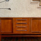 Crafted with attention to detail, this Mid Century Modern "Fresco" Teak Credenza by G Plan features four dovetail drawers for convenient storage, seamlessly integrated with additional storage on either side, offering even more organizational space.