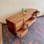 Enhance your bedroom with this Vintage KRUG Walnut 9 Drawer Dresser. The warm, rich color of the walnut complements any decor. Its sleek handle pulls add a touch of elegance to the design. With 9 spacious drawers, this dresser provides ample storage. 