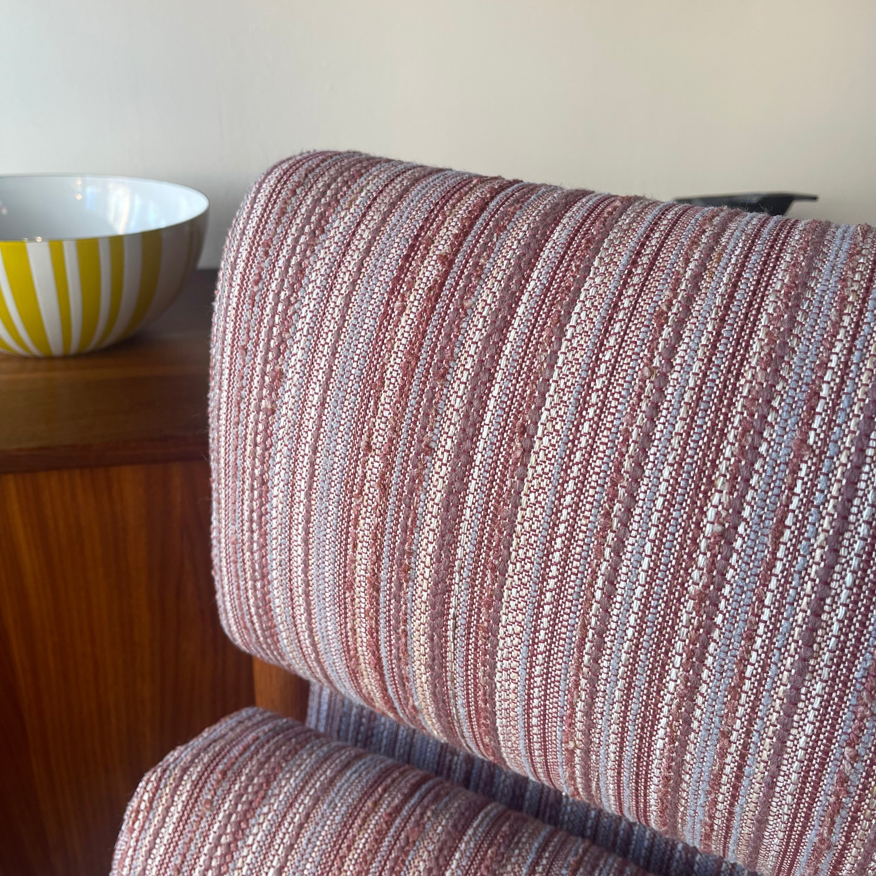 Close-up of blush pink and cream striped upholstery on Danish lounge chair