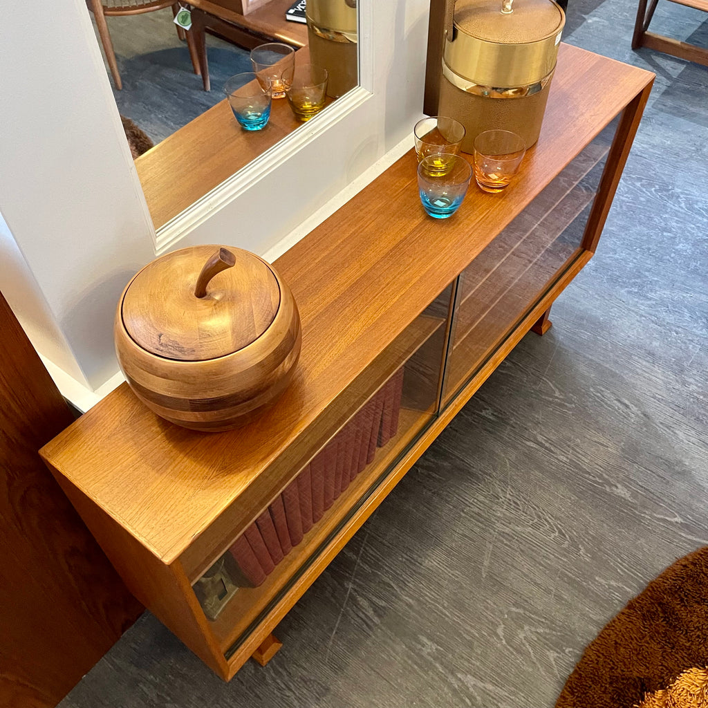 This 1960s Danish Mid Century Hutch exudes timeless elegance with its sleek design and functional features. It has three adjustable shelves, perfect for showcasing your most cherished items. The two sliding glass doors add a touch of sophistication while allowing easy access to your display pieces.