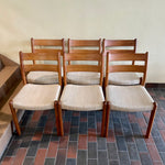 Load image into Gallery viewer, This set of six Danish Modern Solid Teak Dining Chairs from EMC Møbler showcase a sturdy craftsmanship and timeless design. Crafted from solid teak, these chairs feature a sleek and ergonomic silhouette, embodying the minimalist elegance characteristic of mid-century Danish furniture. 
