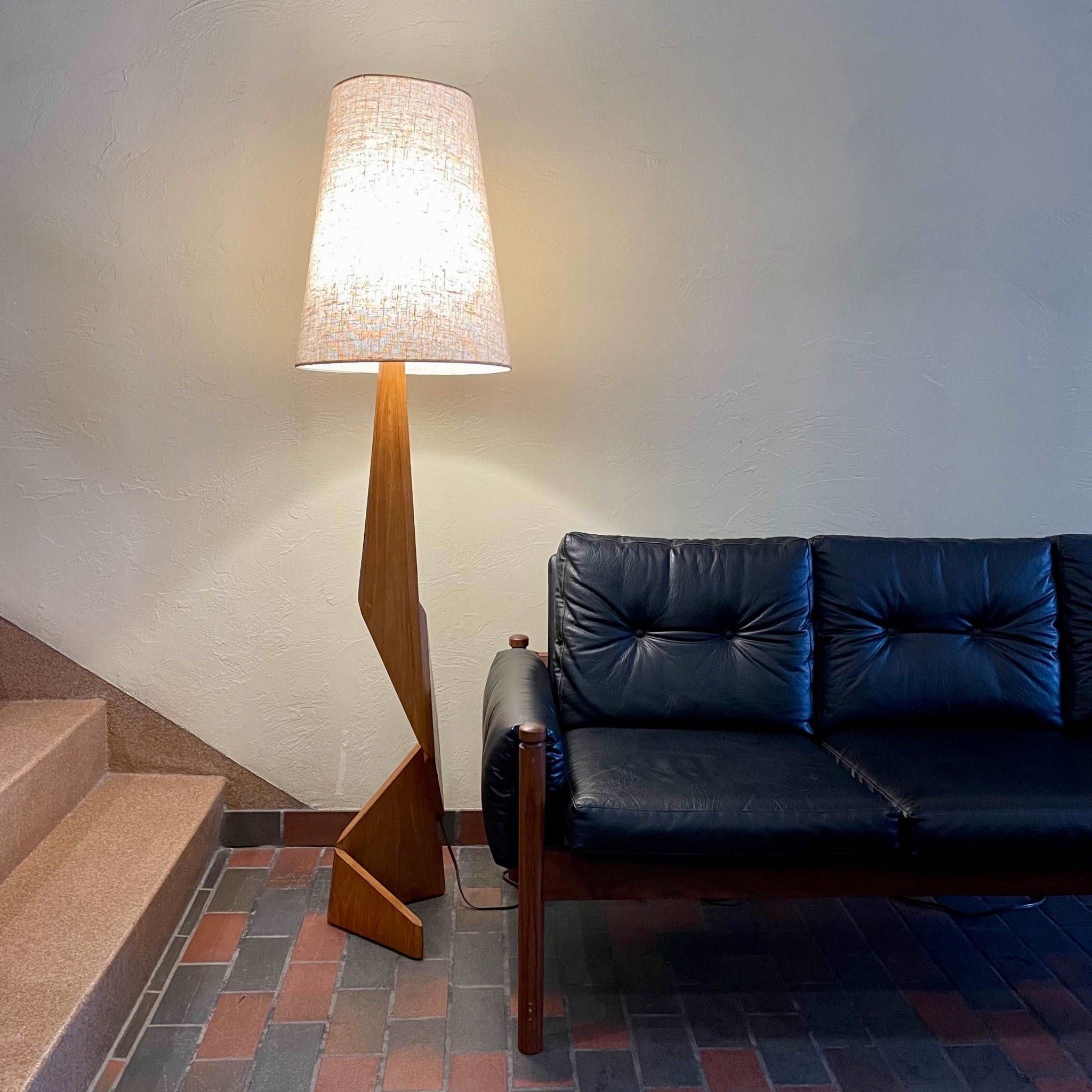 Mid-century teak zig zag floor lamp with sculptural wood base illuminated