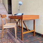  This Mid Century Danish Teak Desk epitomizes timeless design with its sleek lines and warm teak wood. Featuring two drawers, it offers practical storage while maintaining a minimalist aesthetic.