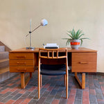 Load image into Gallery viewer, Constructed from rich and durable teak wood, this DYRLUND desk features a design that encapsulates the essence of Mid-Century Modern aesthetics. To the right, a spacious drawer provides practical storage for documents, ensuring a clutter-free workspace. On the left, three drawers offer additional organizational space, perfect for keeping essentials close at hand.