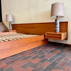 The centerpiece of any bedroom, this platform bed features a clean, minimalist design with a low-profile frame that offers a sense of spaciousness. The headboard, showcasing the natural beauty of teak, adds a touch of organic allure to the overall aesthetic. Its seamless integration with the floating nightstands on both sides creates a cohesive and balanced look.