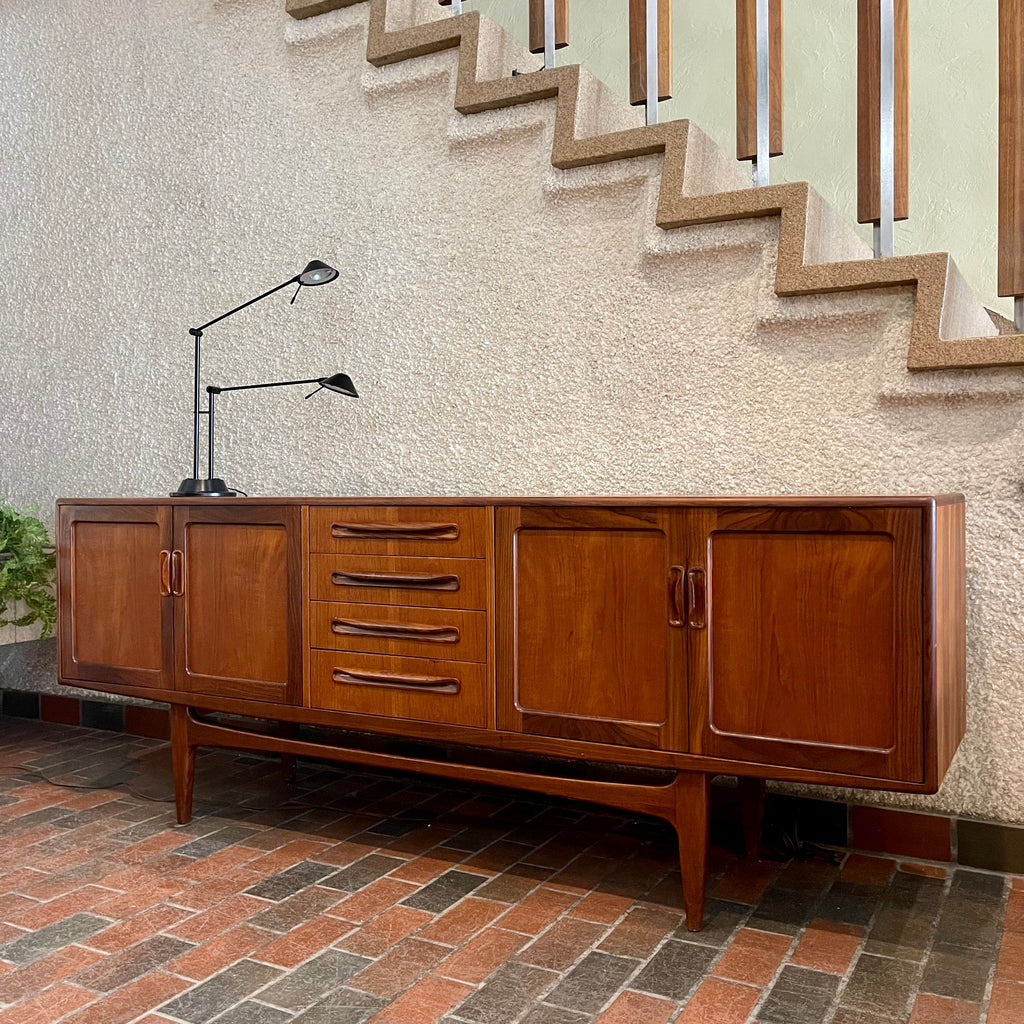 Crafted with attention to detail, this Mid Century Modern "Fresco" Teak Credenza by G Plan features four dovetail drawers for convenient storage, seamlessly integrated with additional storage on either side, offering even more organizational space.