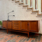 Crafted with attention to detail, this Mid Century Modern "Fresco" Teak Credenza by G Plan features four dovetail drawers for convenient storage, seamlessly integrated with additional storage on either side, offering even more organizational space.
