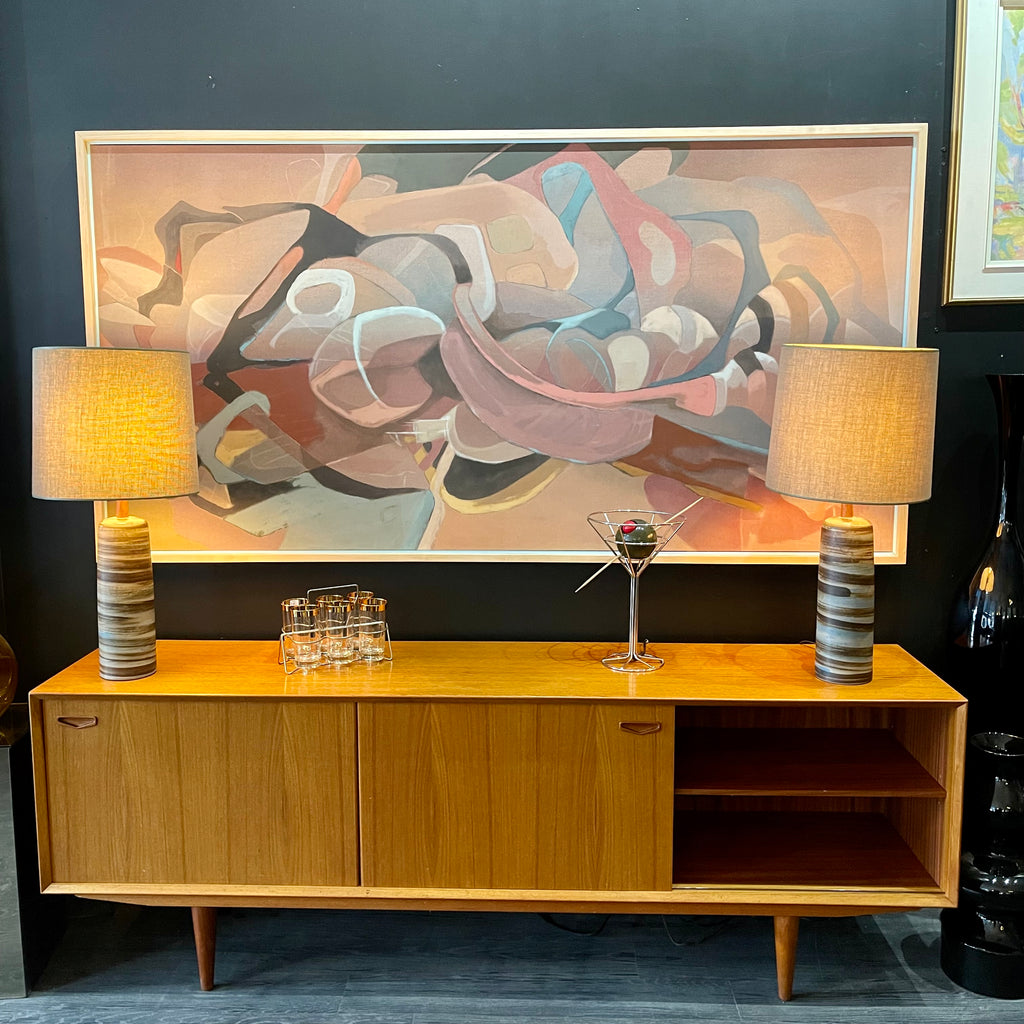 1960s Danish Teak Credenza is a beautiful blend of mid-century design and functionality. Crafted from teak, it features two sliding doors on either side that open to reveal ample storage space with adjustable shelving