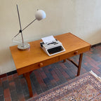  This Mid Century Danish Teak Desk epitomizes timeless design with its sleek lines and warm teak wood. Featuring two drawers, it offers practical storage while maintaining a minimalist aesthetic.