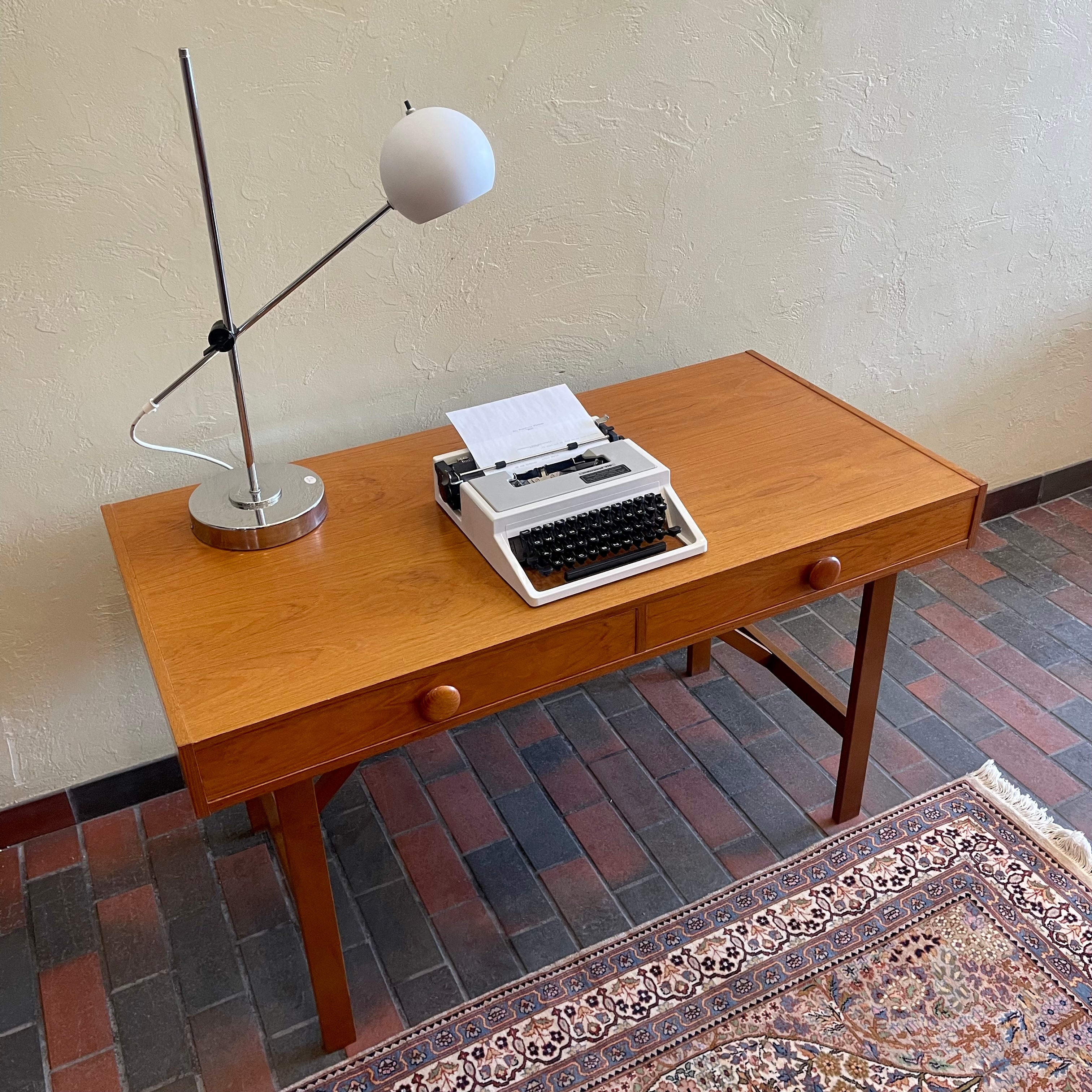  This Mid Century Danish Teak Desk epitomizes timeless design with its sleek lines and warm teak wood. Featuring two drawers, it offers practical storage while maintaining a minimalist aesthetic.