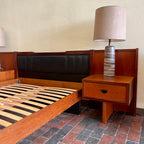 Built-in teak nightstand on R.S. Associates bed with black vinyl-lined drawer