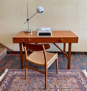  This Mid Century Danish Teak Desk epitomizes timeless design with its sleek lines and warm teak wood. Featuring two drawers, it offers practical storage while maintaining a minimalist aesthetic.