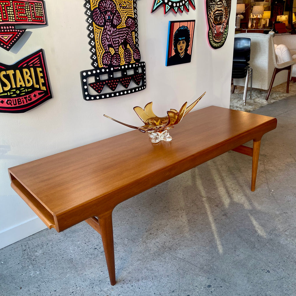 Left side view of Johannes Andersen teak console table with rounded top and tapered leg