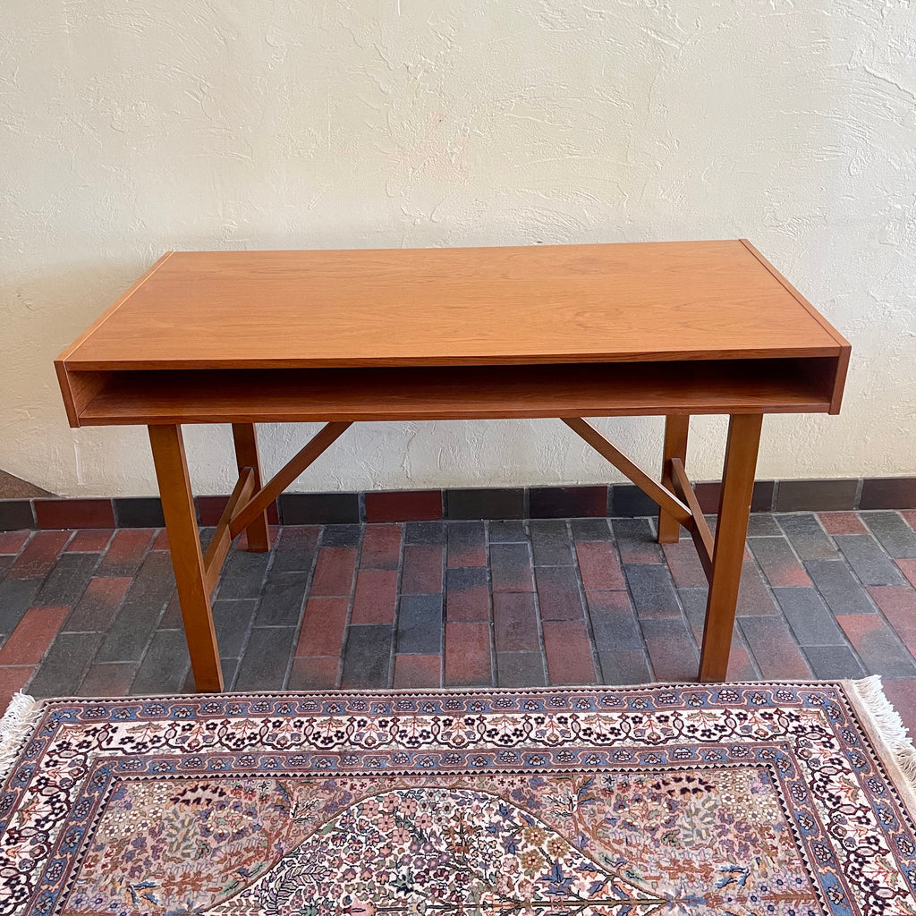  This Mid Century Danish Teak Desk epitomizes timeless design with its sleek lines and warm teak wood. Featuring two drawers, it offers practical storage while maintaining a minimalist aesthetic.